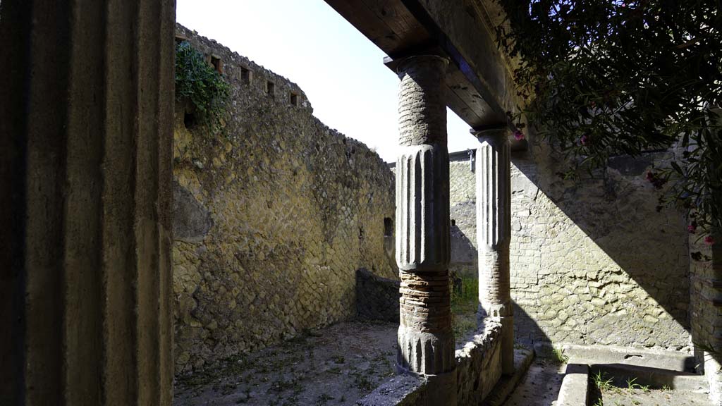 V.15 Herculaneum. August 2021.
Looking south across east portico towards kitchen area, with niche in both the east and south walls. Photo courtesy of Robert Hanson.